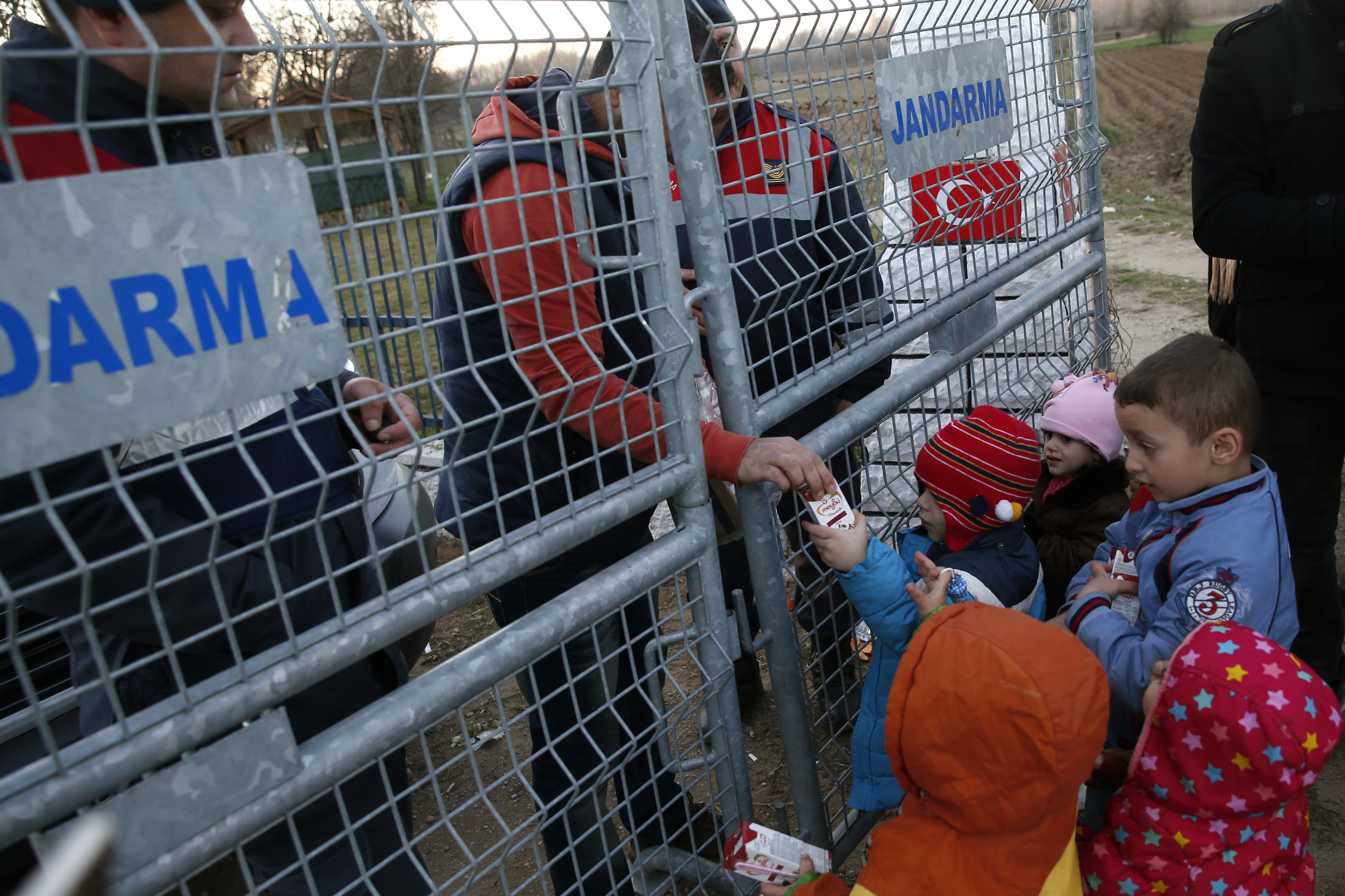 Humanitární pracovníci rozdávají dětem na řecko-turecké hranici mléko