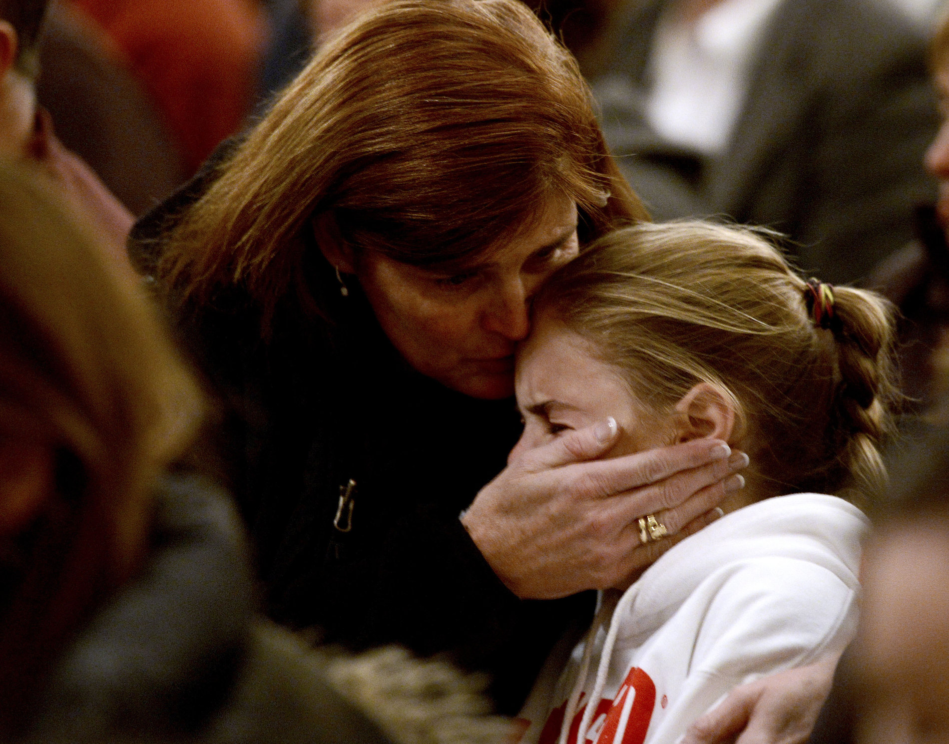 Žena uklidňuje dívku během vigilie za oběti masakru na základní škole Sandy Hook.