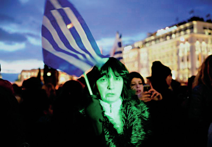 A woman holds a Greek flag as she takes part in an anti-austerity pro-government demonstration in front of the parliament in Athens February 11