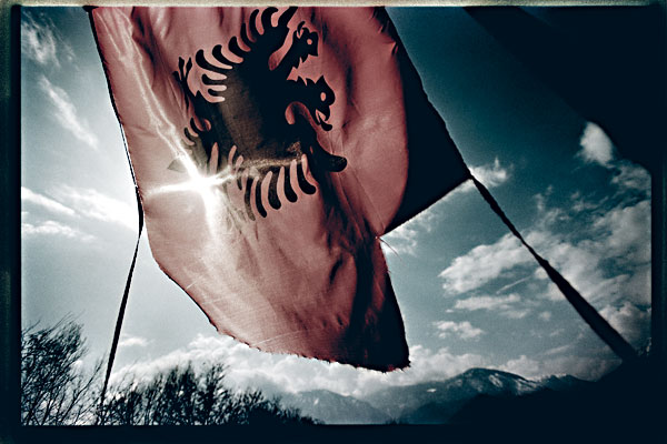 Fotografie: TOMKI NĚMEC &ndash; PEĆ / KOSOVO, ÚNOR 2008
</p>
<p>
Kosovo, hřbitov kosovských Albánců poblíž města Peć. Symbol vlaje drsnými klimatickými podmínkami, jako by naznačoval rozbitost a názorovou roztříštěnost světa na vyhlášení samostatnosti Kosova. Peć bylo jedním z nejzničenějších měst na území Kosova poté, co došlo k srbskému ataku na civilisty a masovému exodu v roce 1998. - Autor: Tomki Němec