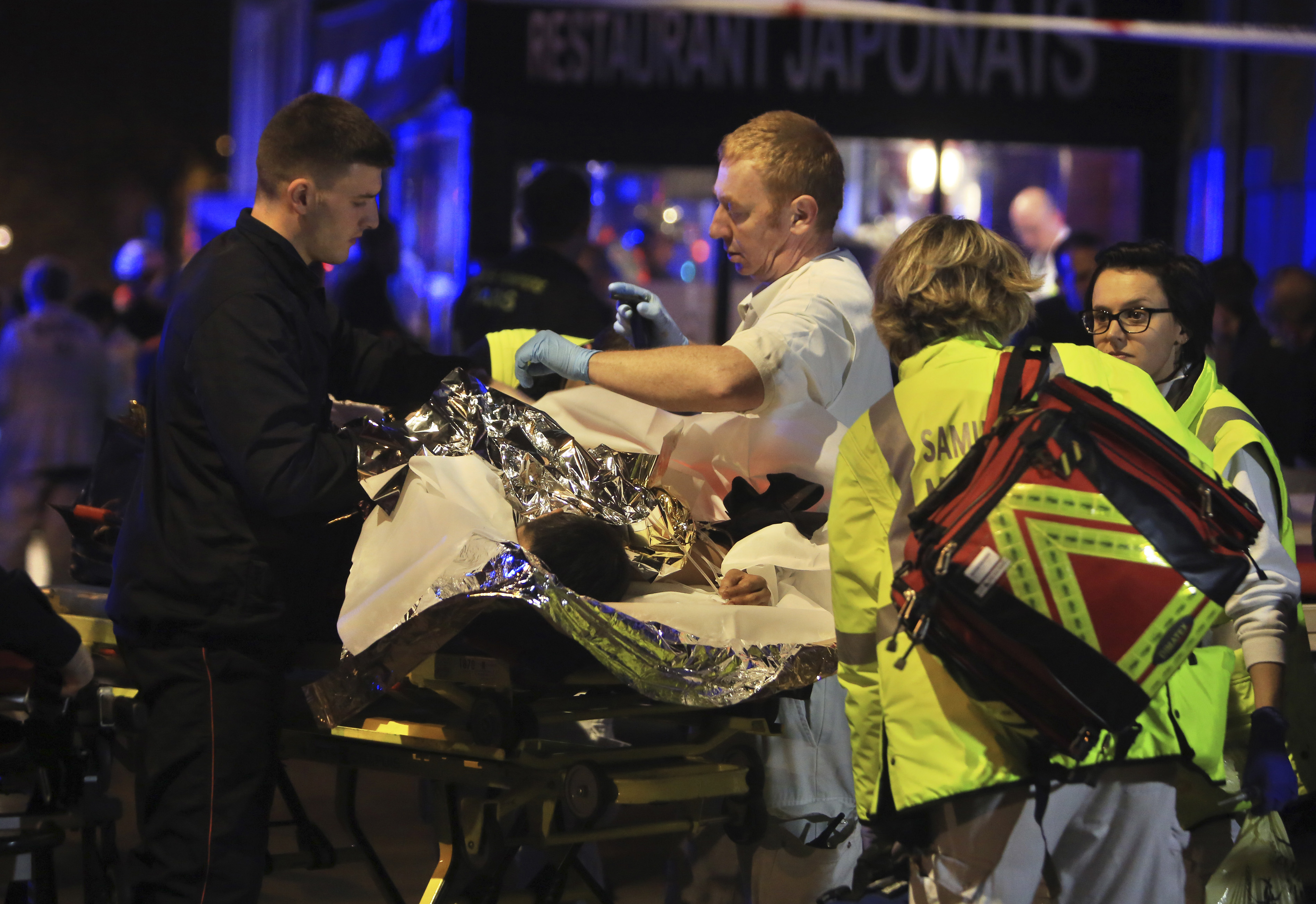 Francouzští záchranáři evakuují zraněné z klubu Bataclan po sérii bombových útoků.