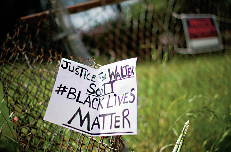 TOPSHOTS
A placard is tied to a fence outside the vacant lot where Walter Scott