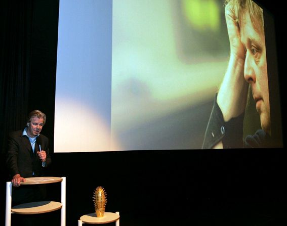 Fotografie: Holandský producent Gijs van de Westelaken při předávání ceny Zlatý kaktus v roce 2005. V pozadí portrét zavražděného režiséra Theo van Gogha. - Autor: Profimedia.cz, http://www.profimedia.cz