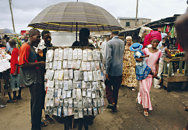 Fotografie: Všudypřítomnost mobilů představuje &bdquo;největší skok v dějinách&ldquo;. (Pouliční prodavač v nigerijském Lagosu) - Autor: Profimedia.cz, http://www.profimedia.cz