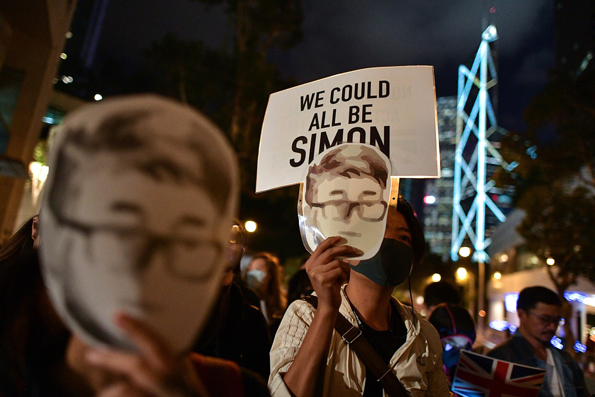 2019: demonstranti před budovou britského konzulátu v Hongkongu nesou masku Simona Chenga, který byl v té době zatčen
