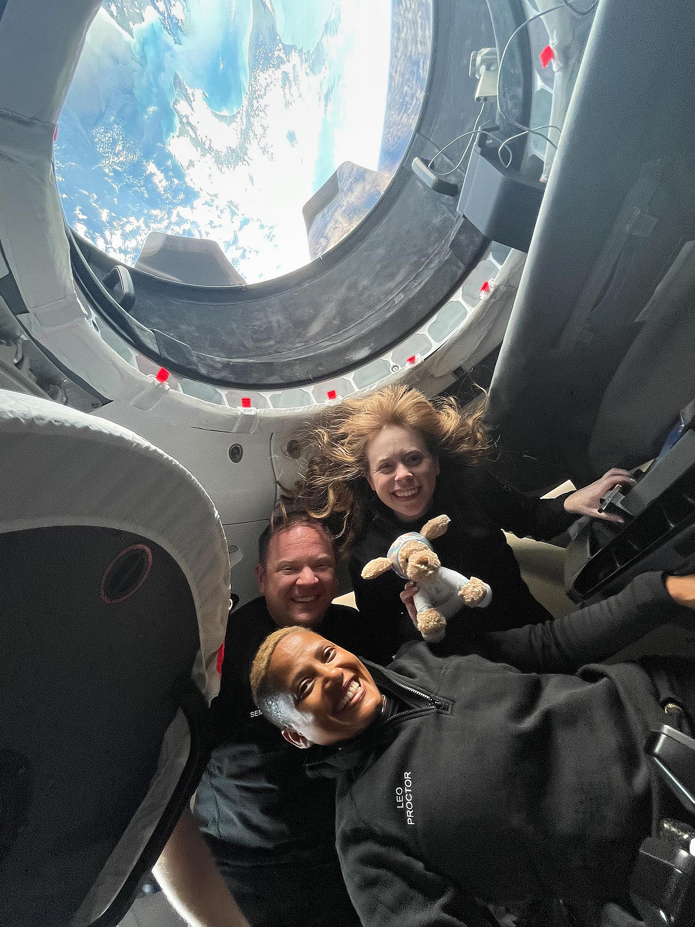 V modravém světle planety spatřil každý něco úplně jiného. (Shora vesmírní „turisté“ Hayley Arceneaux, Chris Sembroski a Sian Proctor během letu v sondě SpaceX, září 2021)