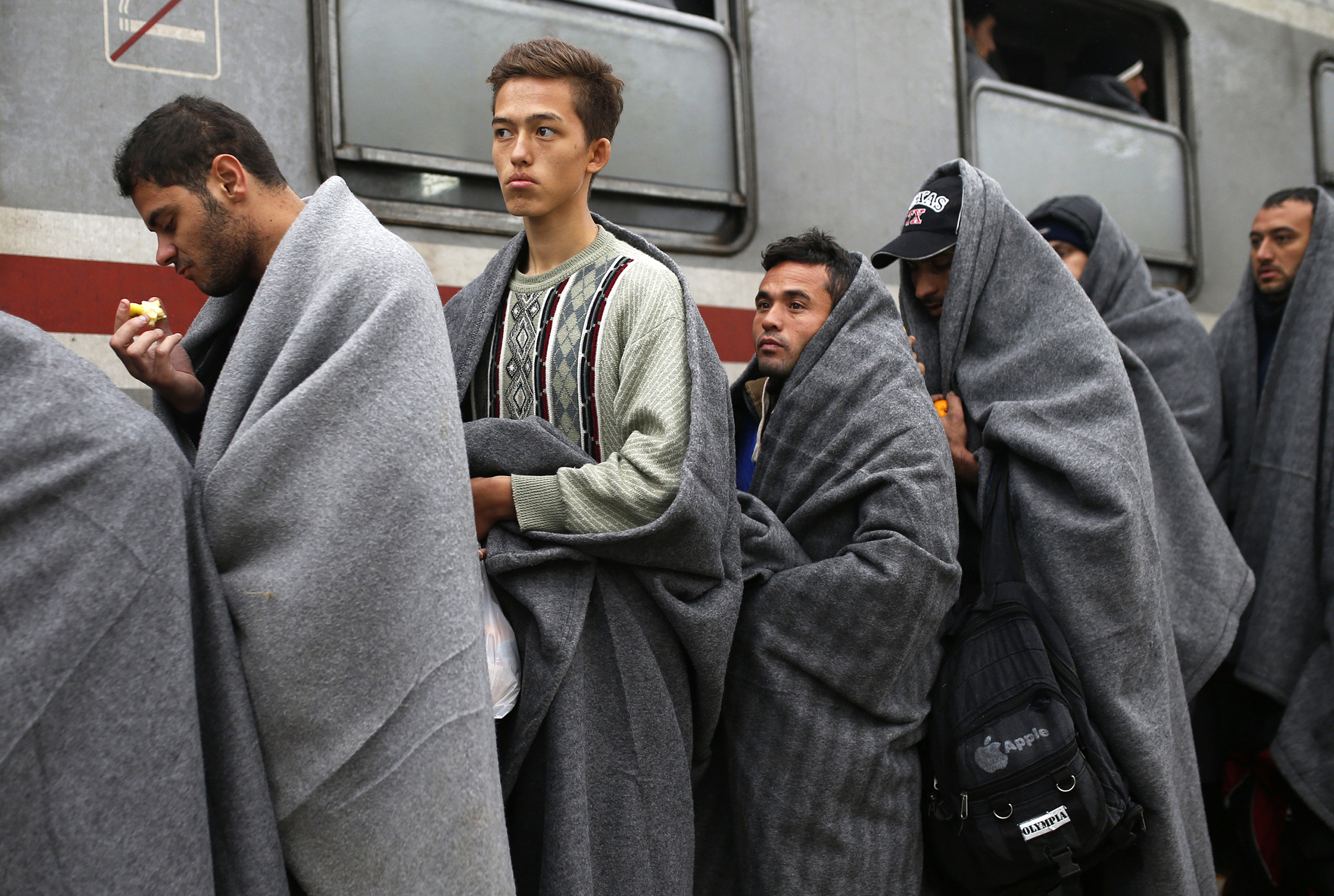 Migrants covered with blankets line up to board a train to continue their journey from Tovarnik, Croatia, October 20, 2015. Slovenia's parliament is expected to approve changes to its laws later on Tuesday to enable the army to help police guard the border, as thousands of migrants flooded into the country from Croatia after Hungary sealed off its border. REUTERS/Dado Ruvic  - RTS57V7