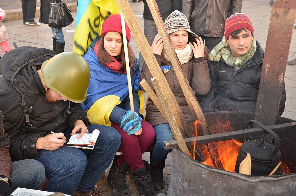 Mladí lidé, především studenti, které školy uvolnily z výuky, se hřejí o ohně a píšou si revoluční deník.